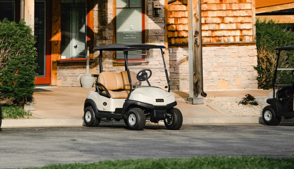 white and black golf cart parked near brown concrete building during daytime