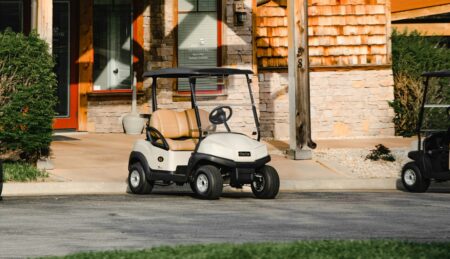 white and black golf cart parked near brown concrete building during daytime